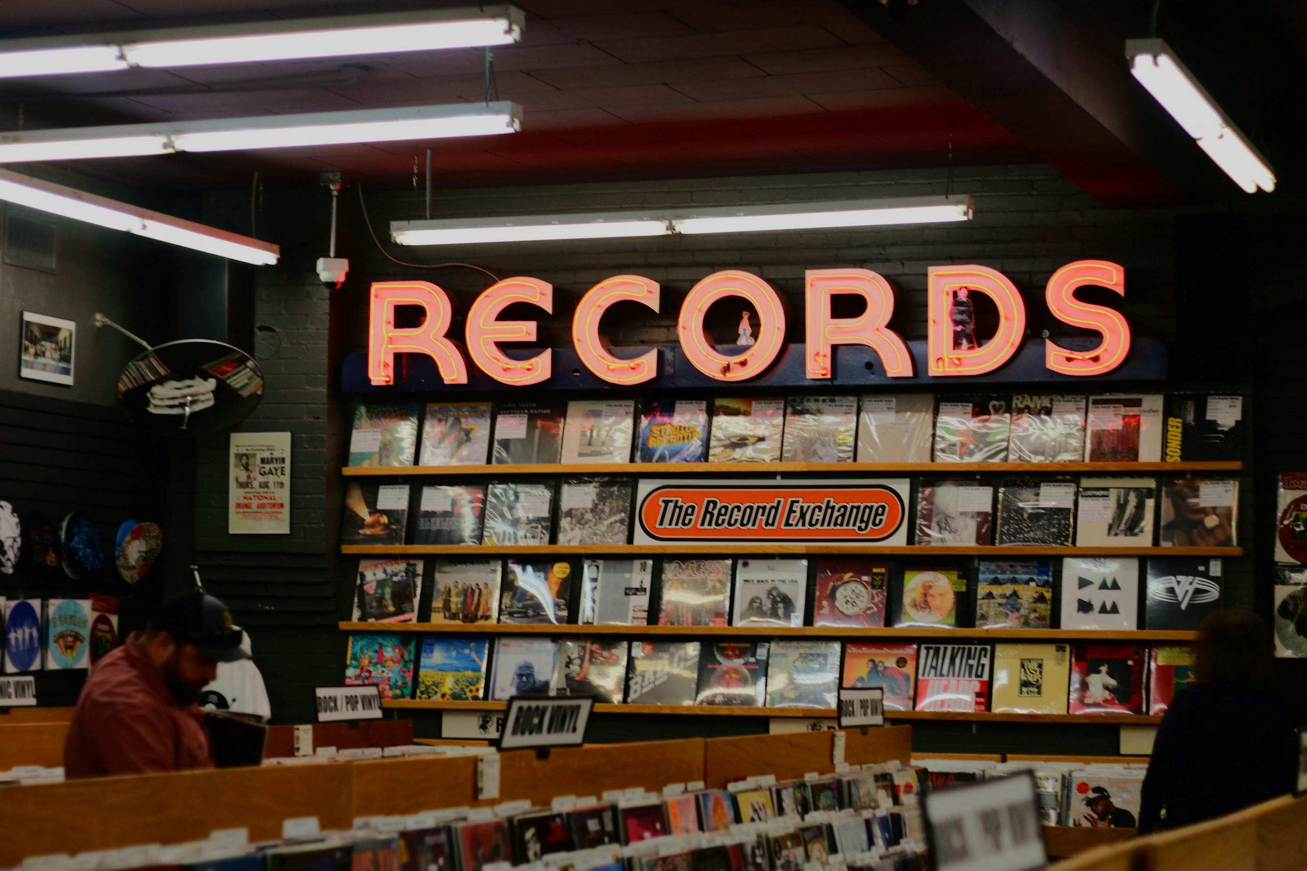 A cozy record store with a vintage vibe, displaying a neon 'Records' sign and assorted vinyl albums.